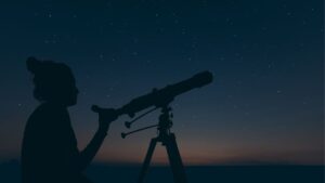 person looking into telescope