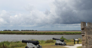Two cannons pointing out at water